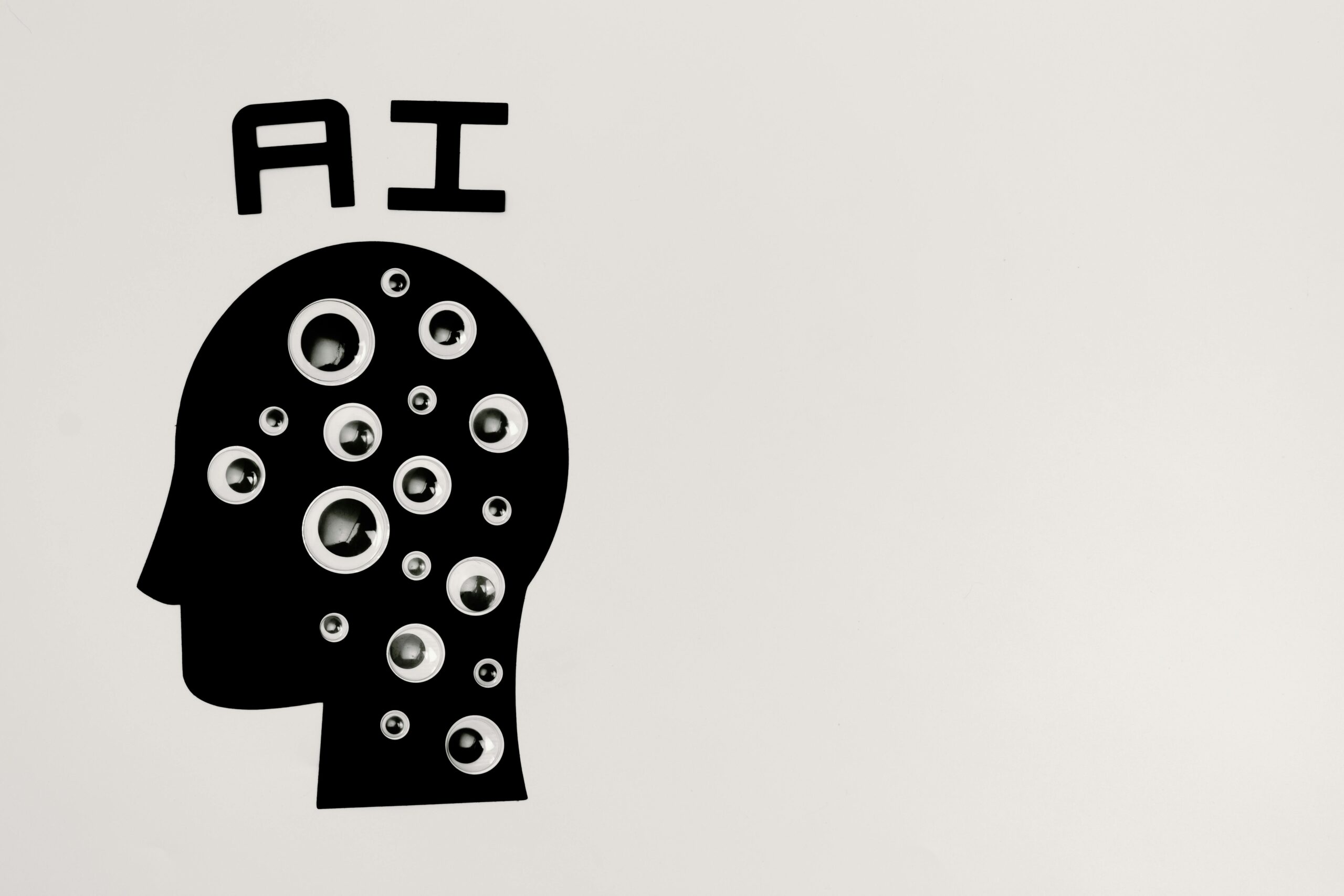 a graphic od a head in black with the letter AI above it and cicrle shapes in the head in white.